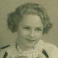 young woman with short fair curly hair smiling