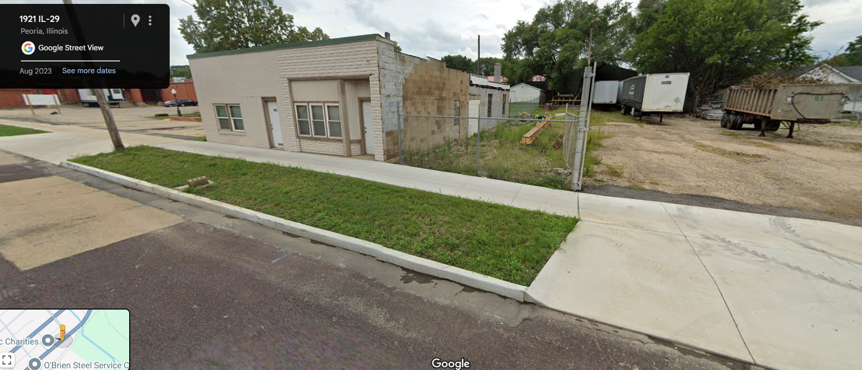 modern day street view of old single story storefront next to a vacant lot