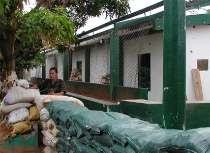 soldier stands by stacks of sand bags