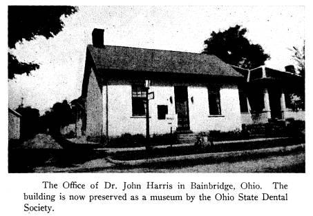 small cottage style building with a street sign in front of it