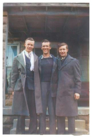 Three young men in long coats smiling