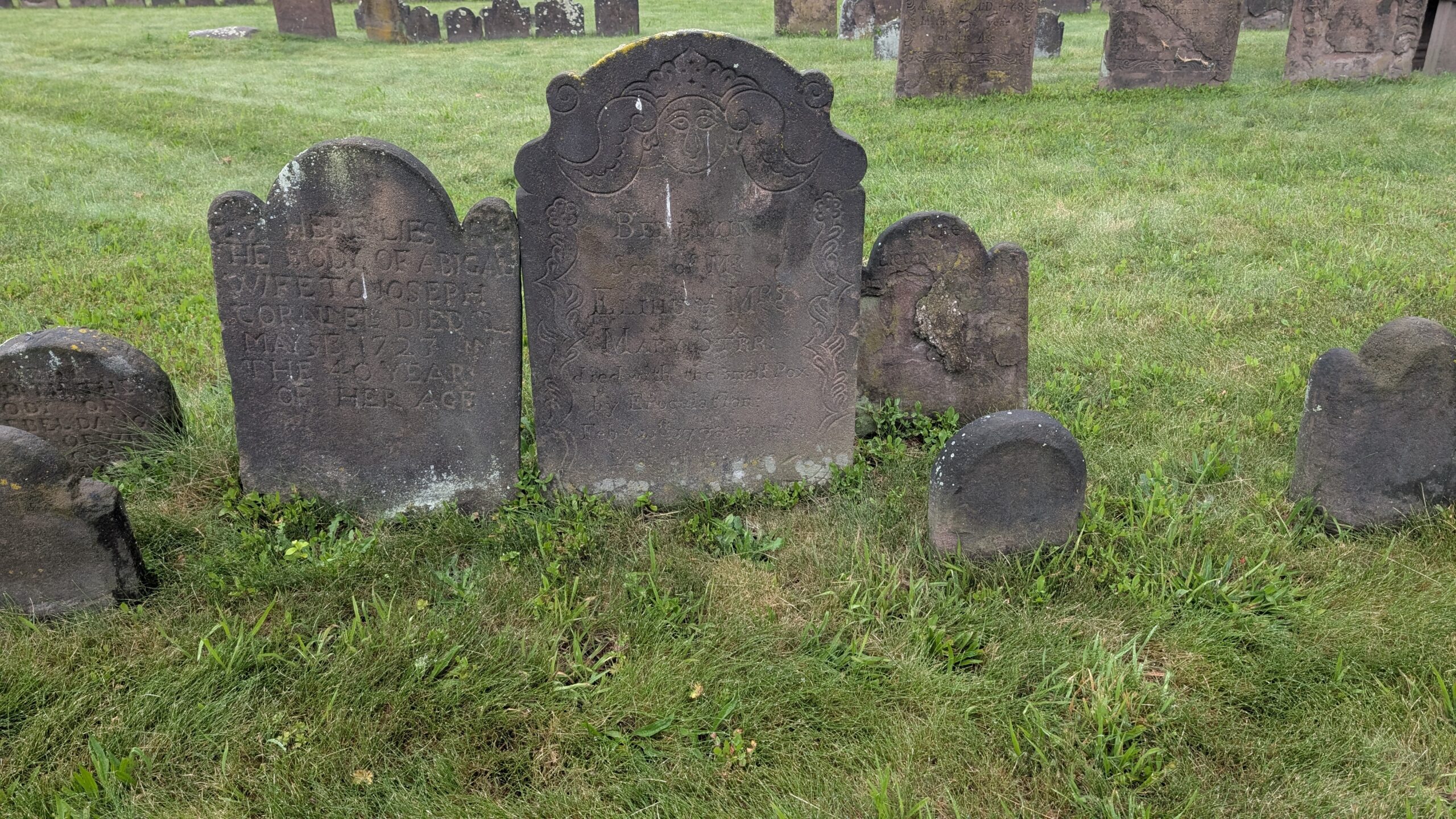 Brownstone grave marker with ornate face and scrollwork reads Benjamin Starr, son of Elihu and Mary Starr died of the small pox by enoculation in his 12th year of age 