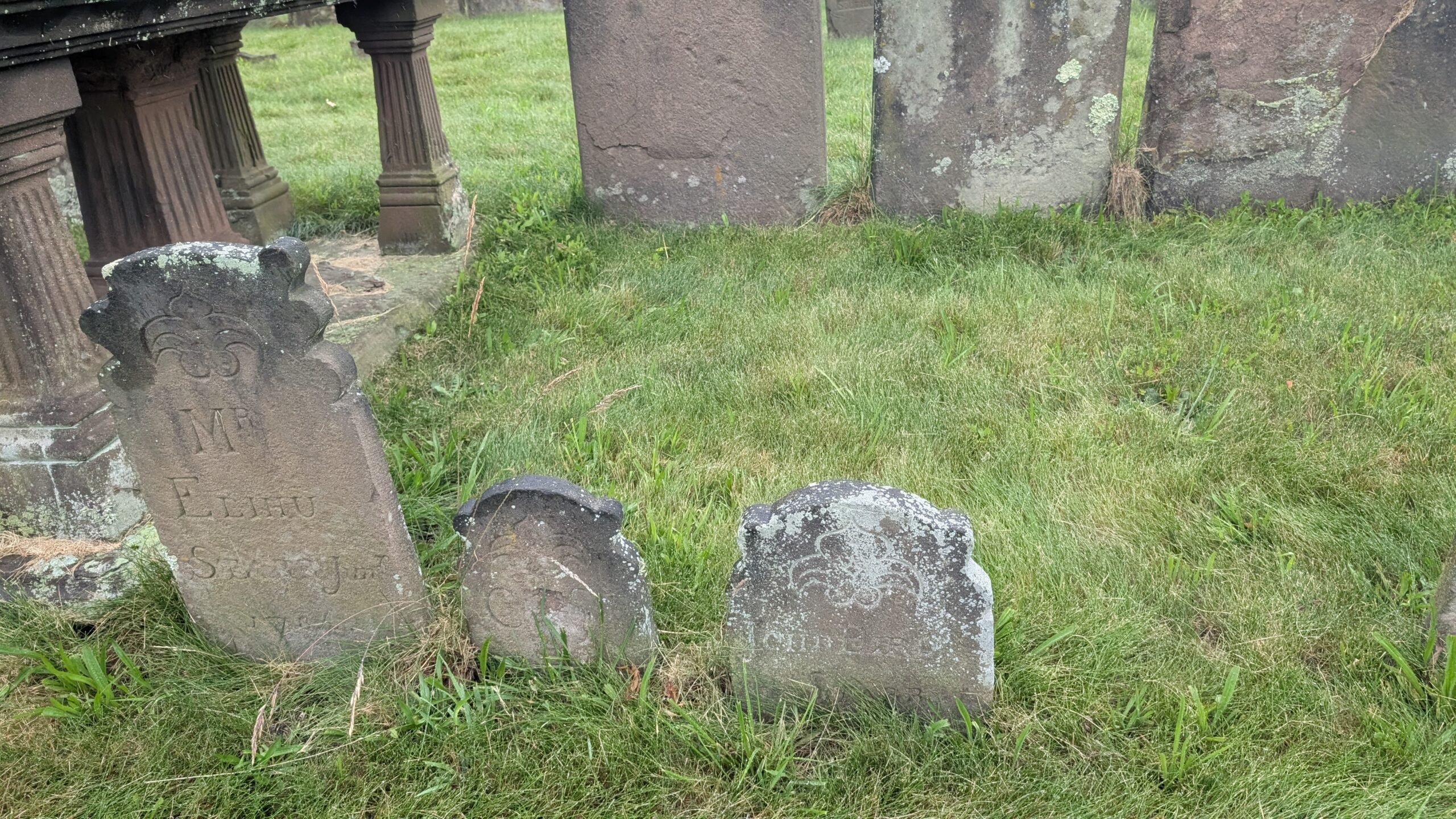 two short grave markers in line with a slightly taller grave stone