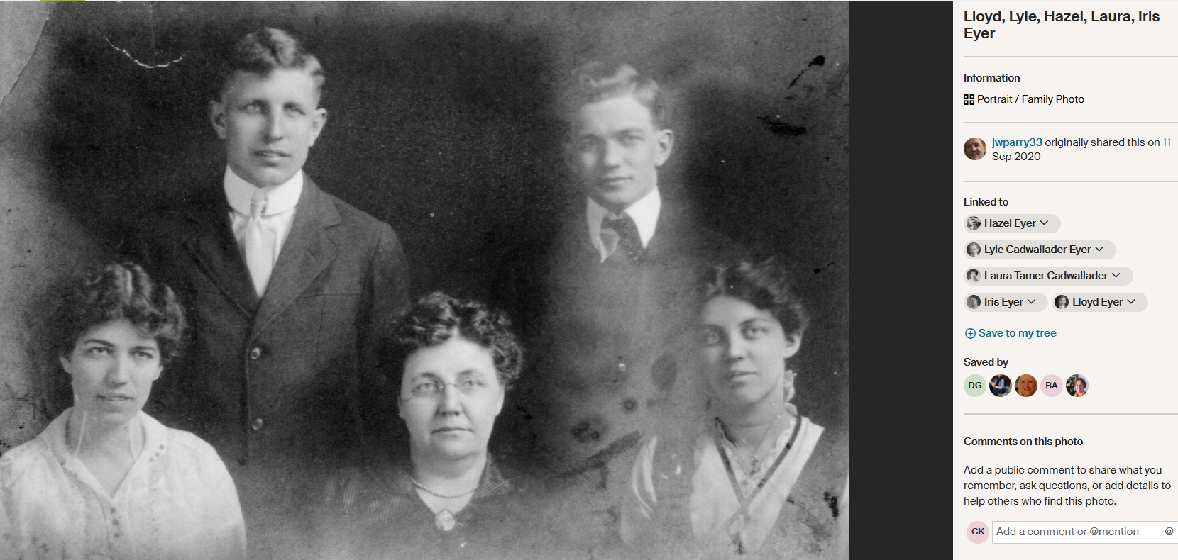 Two young men in suits of the style in the early 1900s stand behind three women, the center woman is older than the others