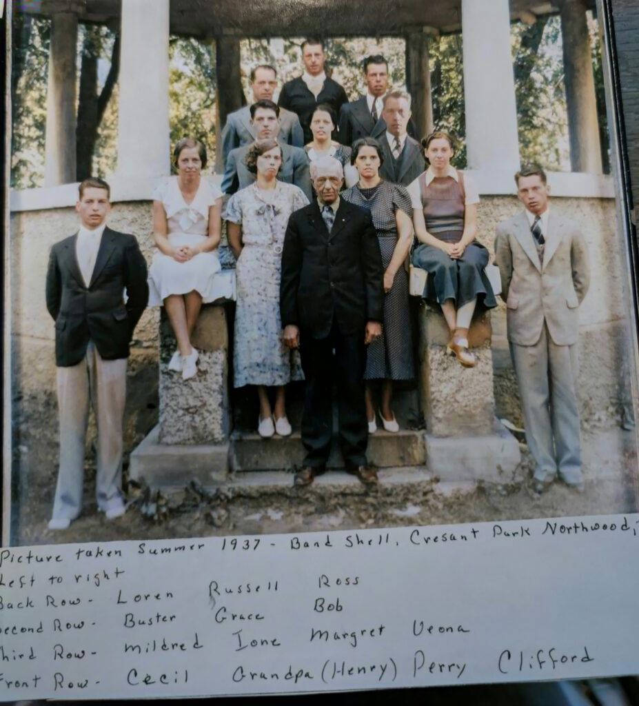 12 young adults behind an older man pose for a picture. 